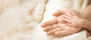 holding newborn baby's hand
